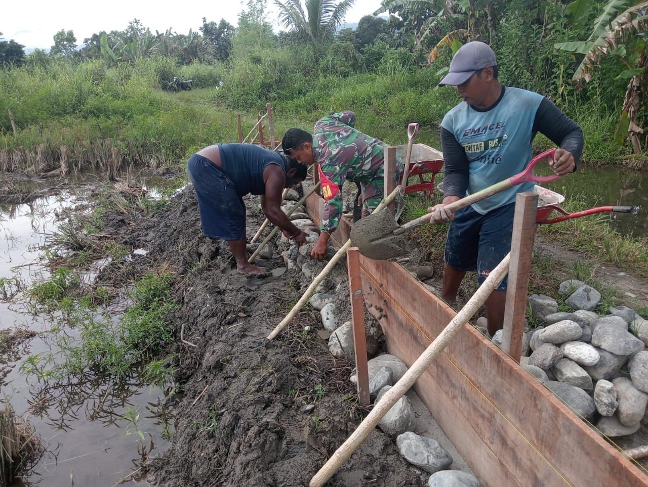 Babinsa Koramil 1801-02/Warmare Melaksanakan Karya Bakti Membantu Warga Membangun Tanggul Penahan Banjir